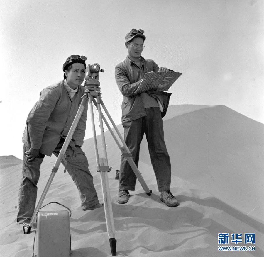 Two young sand control specialists measure the terrain before planting trees in northwest China's Gansu province in May 1957. To ensure the construction of the Baotou-Lanzhou railway, a crucial traffic artery connecting northeast and northwest China, a large tract of sand-binding trees were planted in arid Gansu. (Photo/Xinhua)