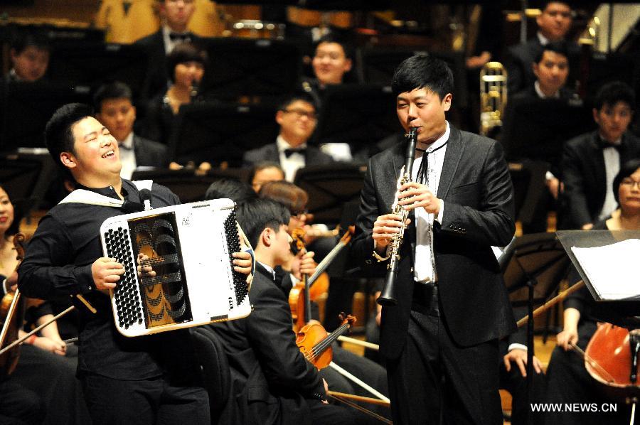 The clarinet artist Yuan Wei (R front) performs "Horse Racing" at Beijing Concert Hall in Beijing, captial of China, March 11, 2013. The Beautiful Emotion concert presented by Zhejiang Symphony Orchestra and the military band of the People's Liberation Army was held here on Monday.(Xinhua/Wang Xiaochuan) 