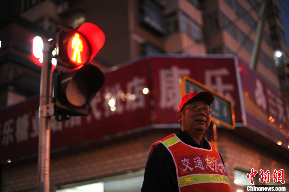 The old man, who prefers anonym, began to work as a traffic warden recently. In a cold afternoon in Oct. in Beijing, he conscientiously fulfills the duties. (Chinanews/Lin Peiqing)