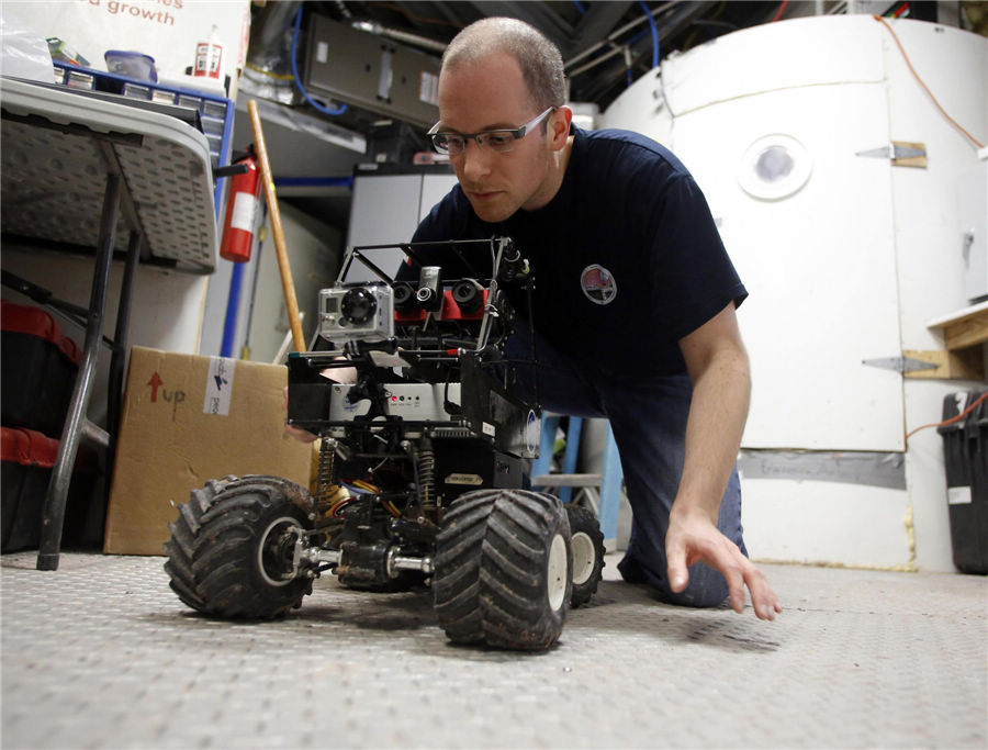 Matt Cross, an engineer with Crew 125 EuroMoonMars B mission, works on a rover at the Mars Desert Research Station (MDRS) outside Hanksville in the Utah desert March 3, 2013. (Photo/Agencies)