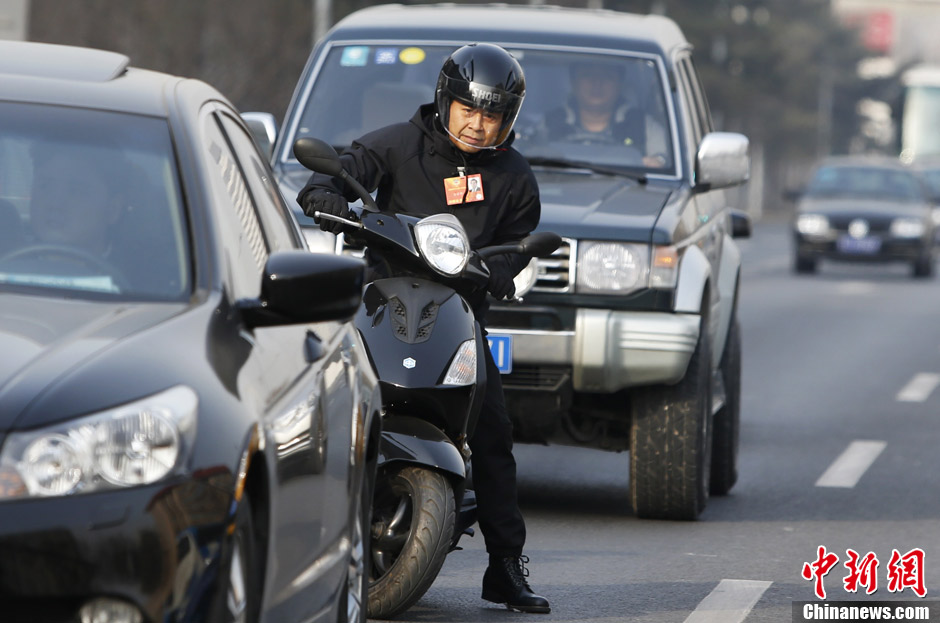 Member of CPPCC National Committee Zuo Zongshen rides a motorbike to experience the traffic condition of Beijing.  (CNS/ Liu Guanguan)