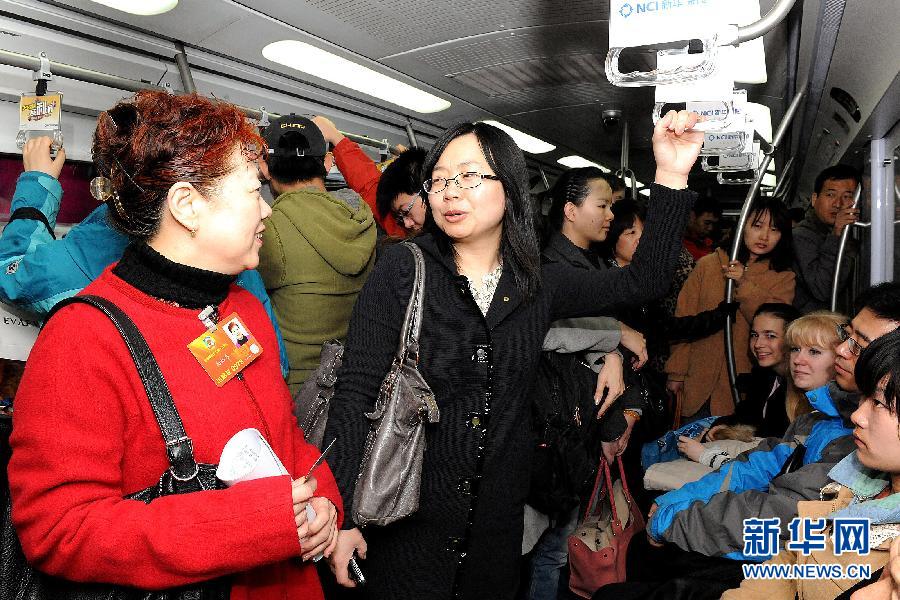 Member of CPPCC National Committee Gao Peifen (L) takes subway to travel from Xuanwumen to Qianmen. (Xinhua/He Junchang)