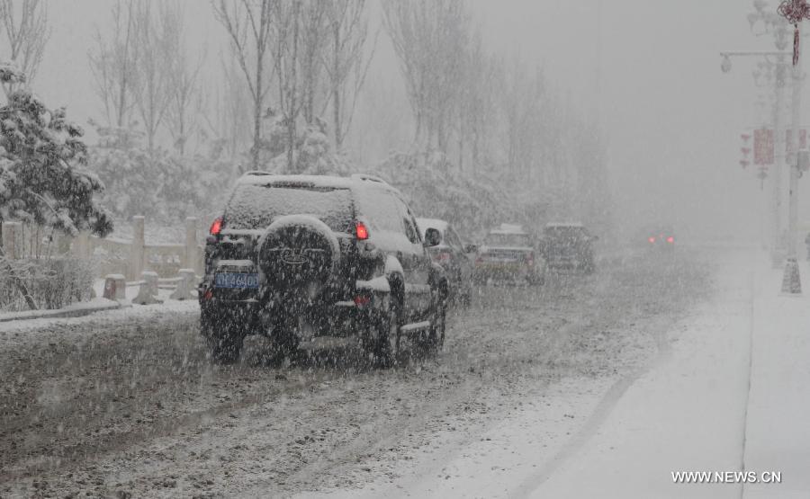 Vehicles move in snow in Pingquan County in north China's Hebei Province, March 12, 2013. Affected by a cold front, the northern part of Hebei received snowfall on Tuesday. (Xinhua/Wang Xiao)