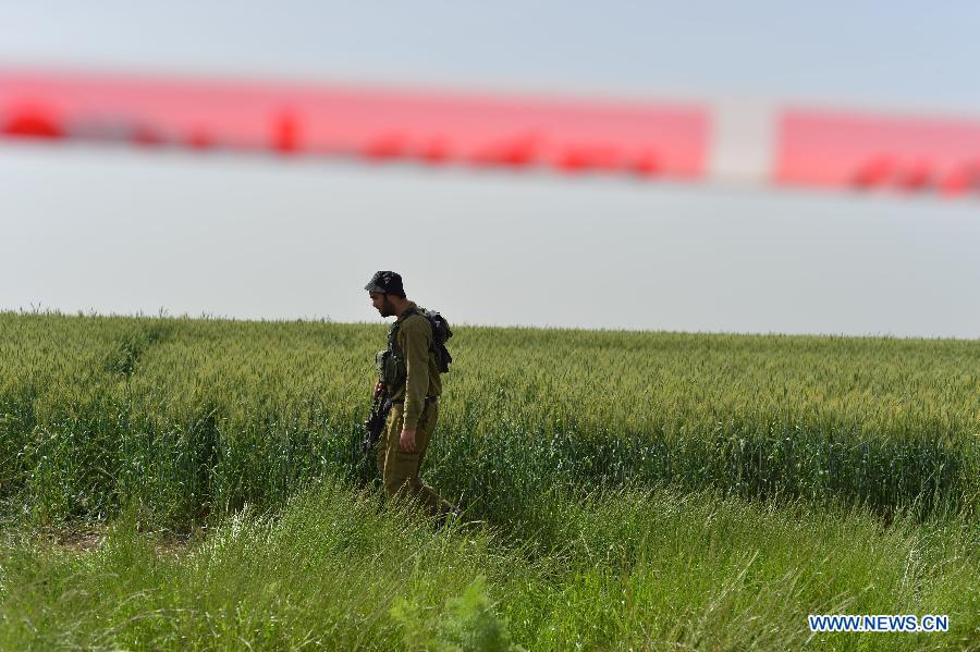 An Israeli soldier guards at the site where an Israeli military helicopter crashed at Kibbutz Revadim in southern Israel on March 12, 2013. An Israel Air Force Bell AH-1 Cobra helicopter crashed into a wheat field at Kibbutz Revadim, killing two crew members, during a training flight on early Tuesday morning, confirmed by Israeli army spokesperson. (Xinhua/Yin Dongxun)