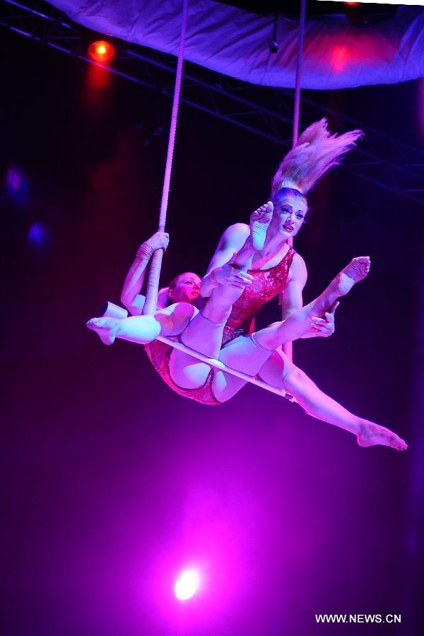 Acrobats perform during the media preview of the circus show "Le Noir" held in the Marina Bay Sands Theatre in Singapore, March 12, 2013. The show with the theme of "Black, white and red" premieres in Singapore Tuesday. (Xinhua/Then Chih Wey) 