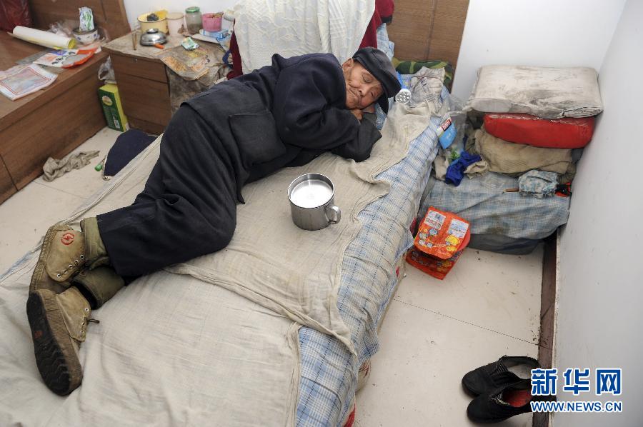An elderly man takes a rest in his bedroom at a rural nursing home in Taiyuan, Shanxi on Oct, 21, 2012. His lunchbox is beside him. (photo/Xinhua)