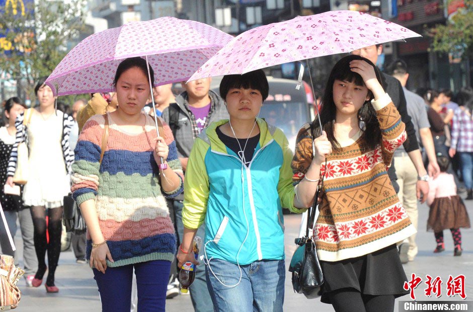 Pedestrians wearing spring clothes walk on the street in Jiangsu on March 9, 2013(Photo/CNS)