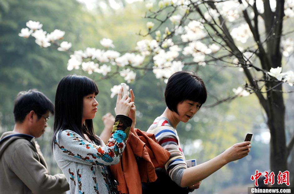 People take photos in a park in Shanghai on March 9, 2013. (Photo/CNS)
