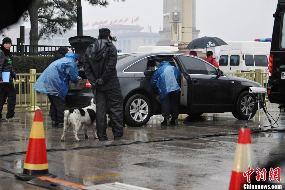 Policemen conduct security check on vehicles in the rain. (CNS/Jin Shuo)