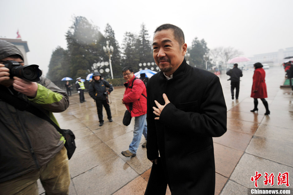 Zhang Guoli, a renowned Chinese actor, enters the Great Hall of the People in rain to attend the meeting. (CNS/Jin Shuo)