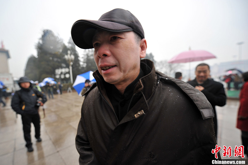 Feng Xiaogang, a successful commercial filmmaker whose comedic films do consistently well in the box office, enters the Great Hall of the People in rain to attend the meeting. (CNS/Jin Shuo)