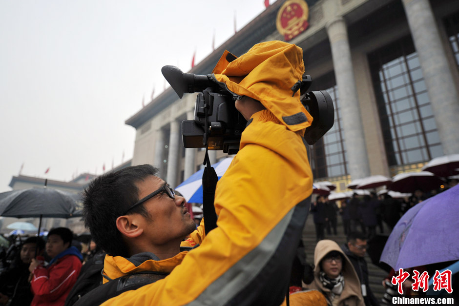 A photographer takes photos of delegates entering the Great Hall of the People. (CNS/Jin Shuo) 