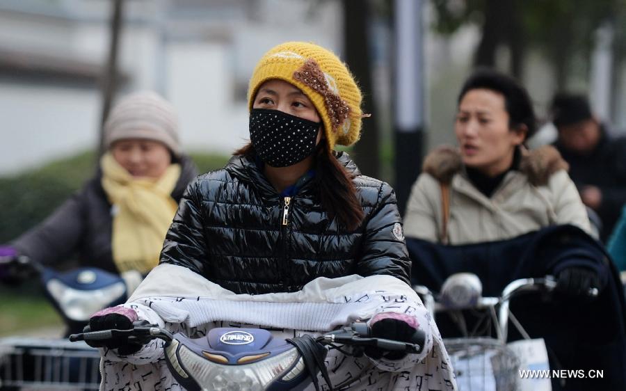Citizens go out in the cold weather in Yangzhou City, east China's Jiangsu Province, March 12, 2013. Affected by a blast of cold air, the temperature in Yangzhou City declined Tuesday. (Xinhua/Meng Delong)  