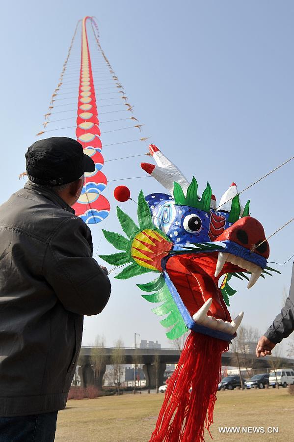 Kite lover flies a kite at the Fenhe Park during a competition in Taiyuan, capital of north China's Shanxi Province, March 13, 2013. (Xinhua/Zhan Yan)
