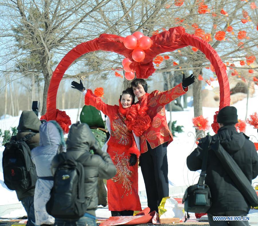 A Russian couple pose for photographers at the mass wedding ceromony in Jiayin, northeast China's Heilongjiang Province, March 13, 2013. Fifty-five pairs of couples, including ten from Russia, took part in a mass wedding here on Wednesday. (Xinhua/Wang Song)