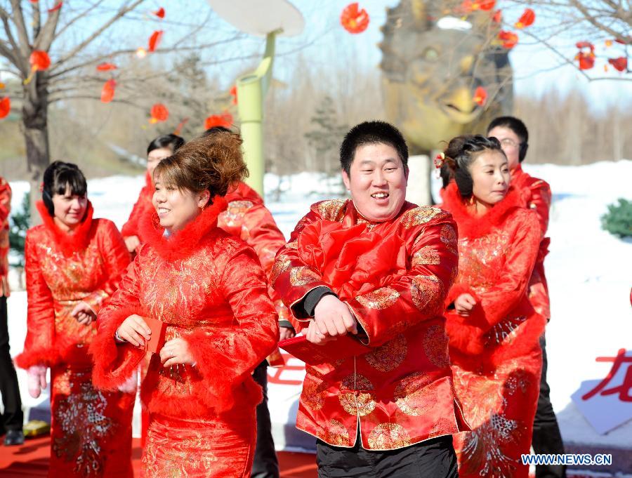 Couples dance during a mass wedding ceromony in Jiayin, northeast China's Heilongjiang Province, March 13, 2013. Fifty-five pairs of couples, including ten from Russia, took part in a mass wedding here on Wednesday. (Xinhua/Wang Song)