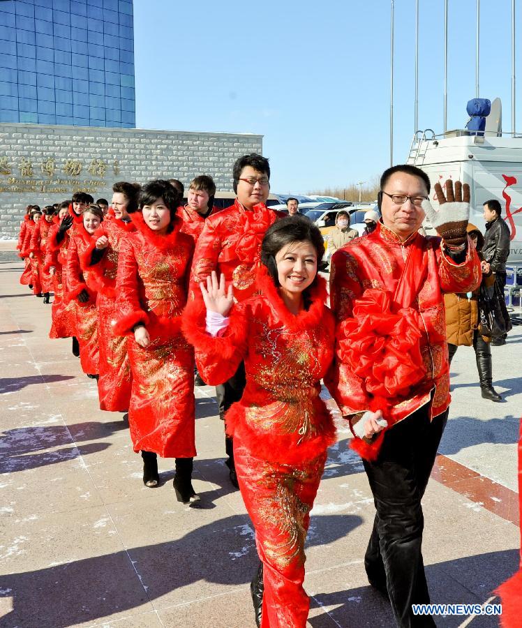 Couples walk into the mass wedding ceromony in Jiayin, northeast China's Heilongjiang Province, March 13, 2013. Fifty-five pairs of couples, including ten from Russia, took part in a mass wedding here on Wednesday. (Xinhua/Wang Song)