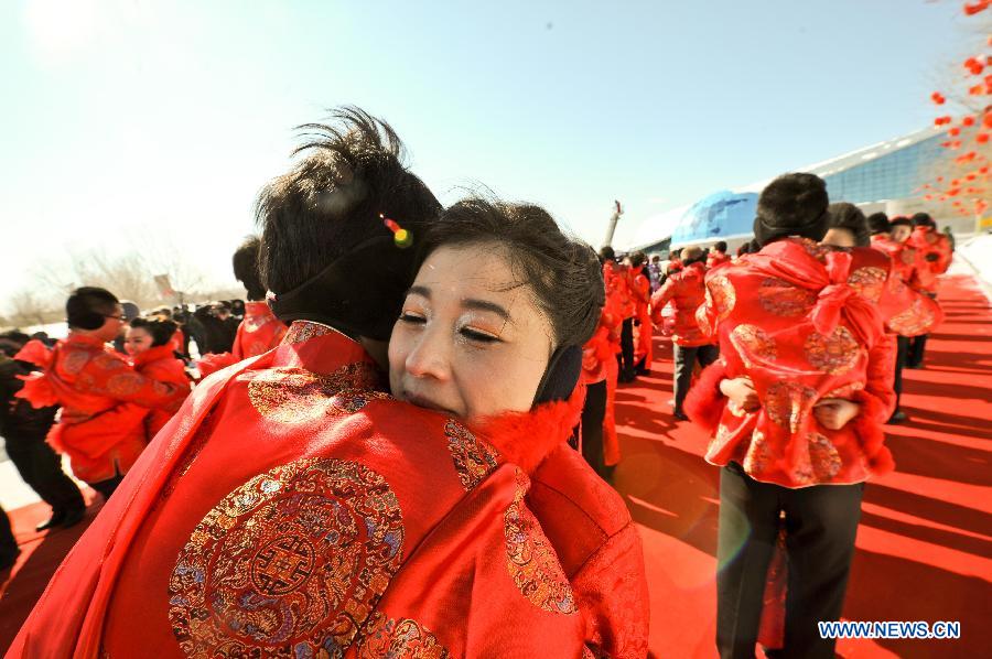Couples hug each other at the mass wedding ceromony in Jiayin, northeast China's Heilongjiang Province, March 13, 2013. Fifty-five pairs of couples, including ten from Russia, took part in a mass wedding here on Wednesday. (Xinhua/Wang Song)