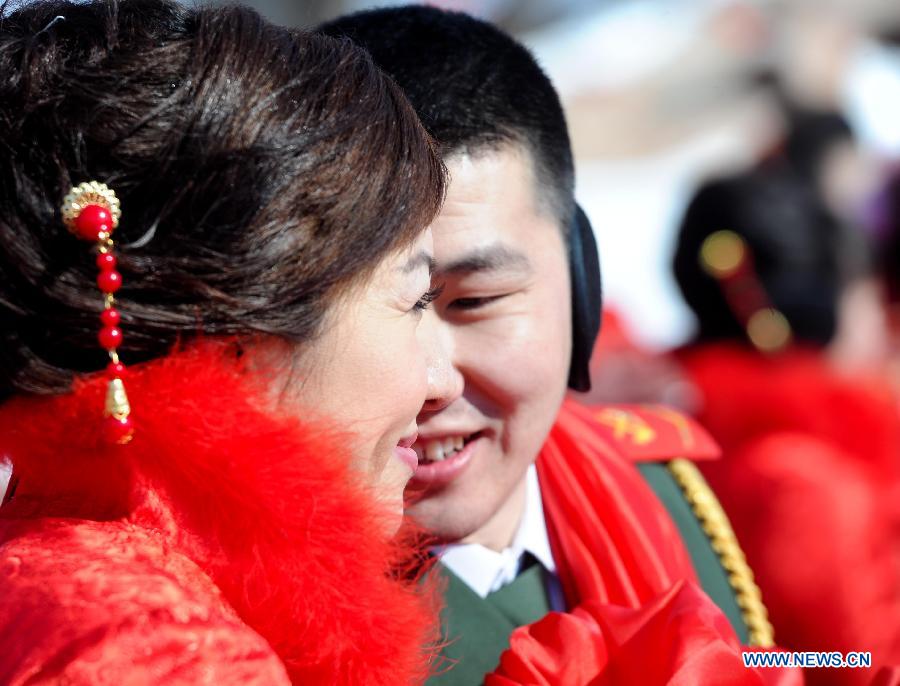 A couple attend a mass wedding ceromony in Jiayin, northeast China's Heilongjiang Province, March 13, 2013. Fifty-five pairs of couples, including ten from Russia, took part in a mass wedding here on Wednesday. (Xinhua/Wang Song)