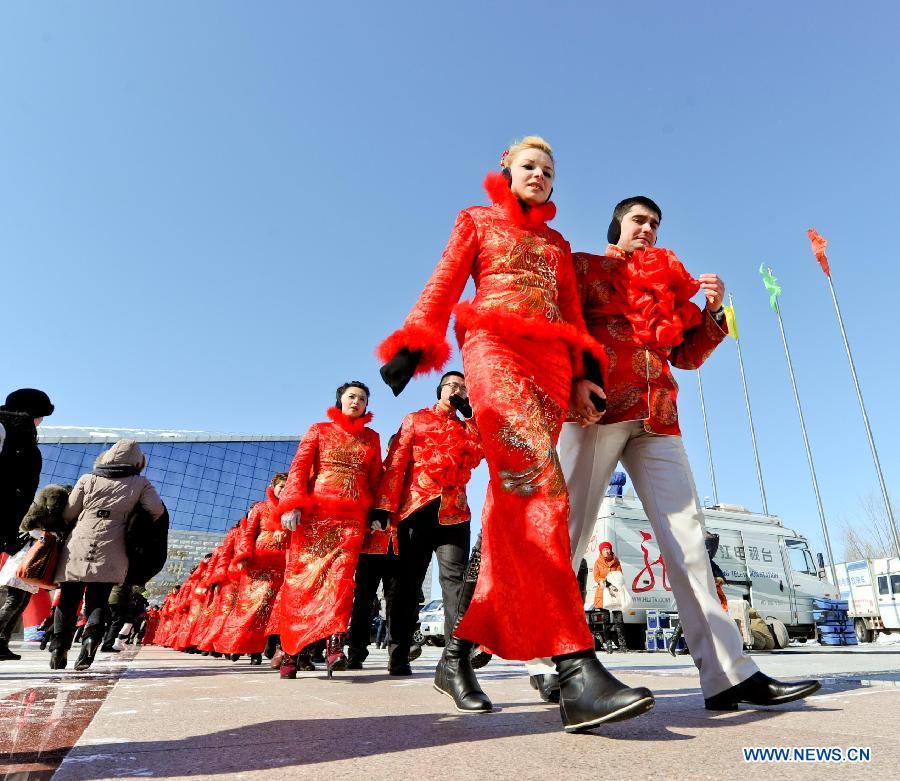 Couples walk into the mass wedding ceromony in Jiayin, northeast China's Heilongjiang Province, March 13, 2013. Fifty-five pairs of couples, including ten from Russia, took part in a mass wedding here on Wednesday. (Xinhua/Wang Song)