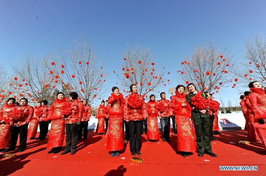 Couples attend a mass wedding ceromony in Jiayin, northeast China's Heilongjiang Province, March 13, 2013. Fifty-five pairs of couples, including ten from Russia, took part in a mass wedding here on Wednesday. (Xinhua/Wang Song)
