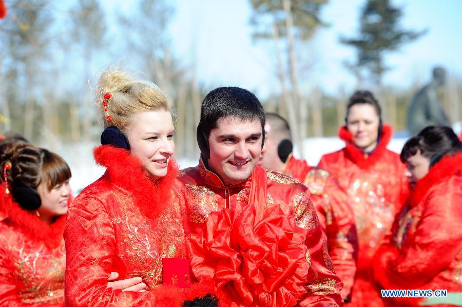 A Russian couple attend a mass wedding ceromony in Jiayin, northeast China's Heilongjiang Province, March 13, 2013. Fifty-five pairs of couples, including ten from Russia, took part in a mass wedding here on Wednesday. (Xinhua/Wang Song)