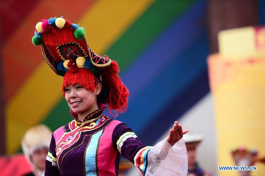 A woman presents folk costumes of Tu ethnic group during a celebration for "Er Yue Er" in Tu Autonomous County of Huzhu, northwest China's Qinghai Province, March 13, 2013, on the occasion of the second day of the second lunar month, known in Chinese as Er Yue Er, "a time for the dragon to raise its head", as a Chinese saying goes. Local residents gathered together and celebrated the festival with traditional performance. (Xinhua/Zhang Hongxiang)  