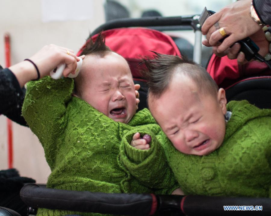 Twin boys cry as having their hair cut at a barbershop in Huaibei City, east China's Anhui Province, March 13, 2013, on the occasion of the second day of the second lunar month, known in Chinese as Er Yue Er, "a time for the dragon to raise its head", as a Chinese saying goes. Barbershops across the country opened early to begin one of their busiest days of the year, as many Chinese hold the superstitious belief that getting a haircut at a time when the "dragon raises its head" means they will have a vigorous start to the new year. (Xinhua/Wang Wen)