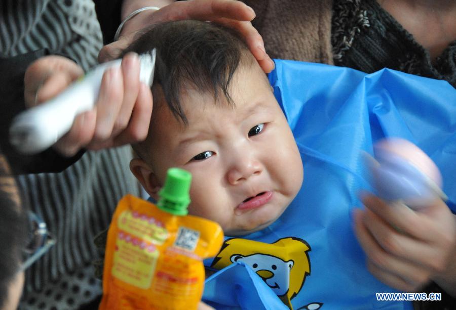 A baby cries as having haircut at a barbershop in Xingtai City, north China's Hebei Province, March 13, 2013, on the occasion of the second day of the second lunar month, known in Chinese as Er Yue Er, "a time for the dragon to raise its head", as a Chinese saying goes. Barbershops across the country opened early to begin one of their busiest days of the year, as many Chinese hold the superstitious belief that getting a haircut at a time when the "dragon raises its head" means they will have a vigorous start to the new year. (Xinhua/Huang Tao)
