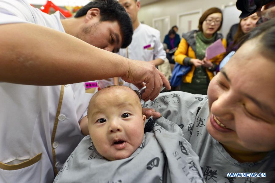 A baby has haircut at a barbershop in Beijing, capital of China, March 13, 2013, on the occasion of the second day of the second lunar month, known in Chinese as Er Yue Er, "a time for the dragon to raise its head", as a Chinese saying goes. Barbershops across the country opened early to begin one of their busiest days of the year, as many Chinese hold the superstitious belief that getting a haircut at a time when the "dragon raises its head" means they will have a vigorous start to the new year. (Xinhua/Zhang Chuandong)