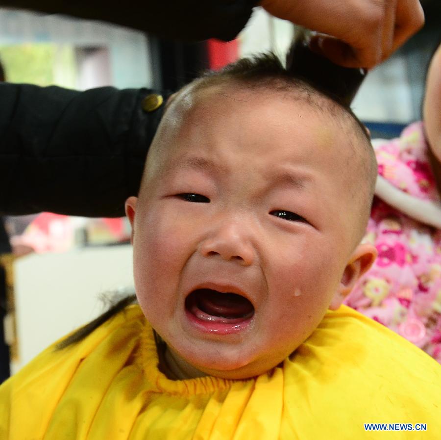A baby cries as having his haircut at a barbershop in Wuxi City, east China's Jiangsu Province, March 13, 2013, on the occasion of the second day of the second lunar month, known in Chinese as Er Yue Er, "a time for the dragon to raise its head", as a Chinese saying goes. Barbershops across the country opened early to begin one of their busiest days of the year, as many Chinese hold the superstitious belief that getting a haircut at a time when the "dragon raises its head" means they will have a vigorous start to the new year. (Xinhua/Hai Yueliang)