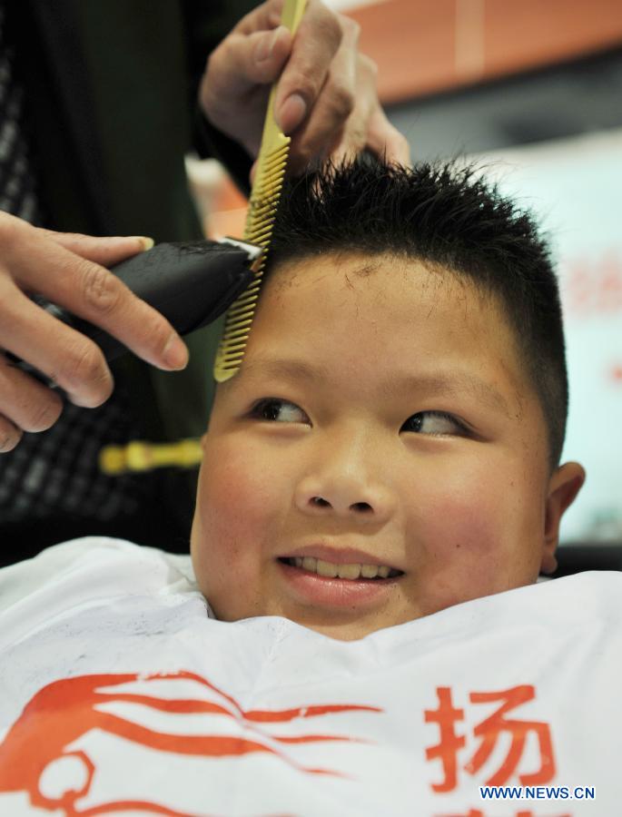 A boy has his hair cut at a barbershop in Suining County of Xuzhou City, east China's Jiangsu Province, March 13, 2013, on the occasion of the second day of the second lunar month, known in Chinese as Er Yue Er, "a time for the dragon to raise its head", as a Chinese saying goes. Barbershops across the country opened early to begin one of their busiest days of the year, as many Chinese hold the superstitious belief that getting a haircut at a time when the "dragon raises its head" means they will have a vigorous start to the new year. (Xinhua/Hong Xing)