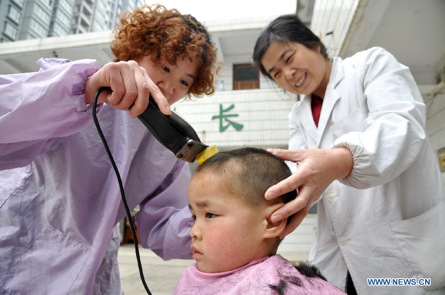 A boy has his haircut at a welfare center in Handan City, north China's Hebei Province, March 13, 2013, on the occasion of the second day of the second lunar month, known in Chinese as Er Yue Er, "a time for the dragon to raise its head", as a Chinese saying goes. Barbershops across the country opened early to begin one of their busiest days of the year, as many Chinese hold the superstitious belief that getting a haircut at a time when the "dragon raises its head" means they will have a vigorous start to the new year. (Xinhua/Hao Qunying)