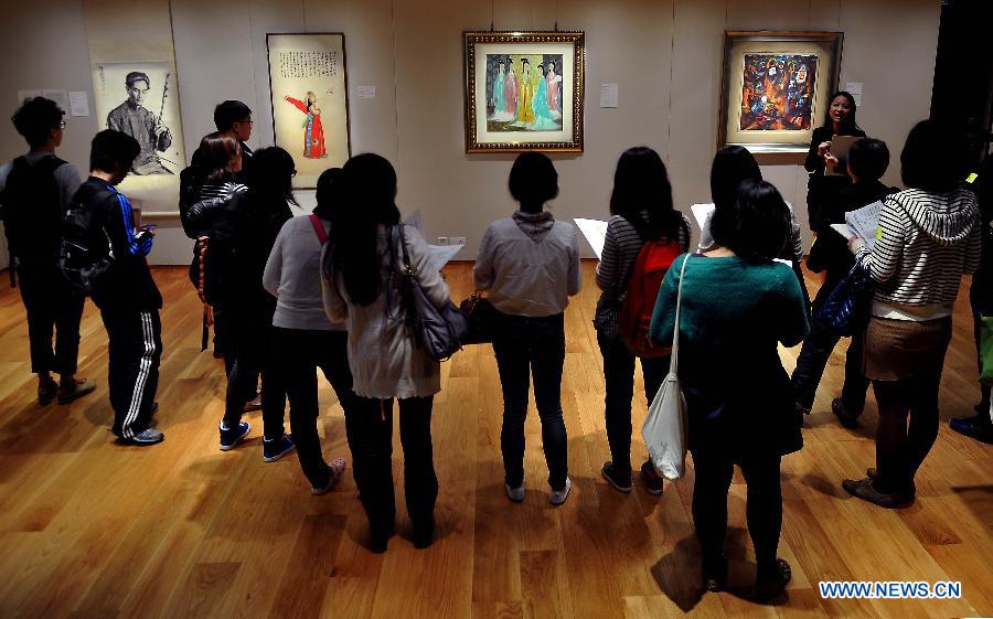 Media workers watch artworks during a preview of spring sales by the Sotheby's in Hong Kong, south China, March 13, 2013. Sotheby's 2013 spring sales of fine Chinese paintings will be held on April 5 in Hong Kong. Over 300 pieces of artworks with a total value of more than 130 million Hong Kong dollars (about 16.6 million U.S. dollars) will be on display. (Xinhua/Chen Xiaowei)