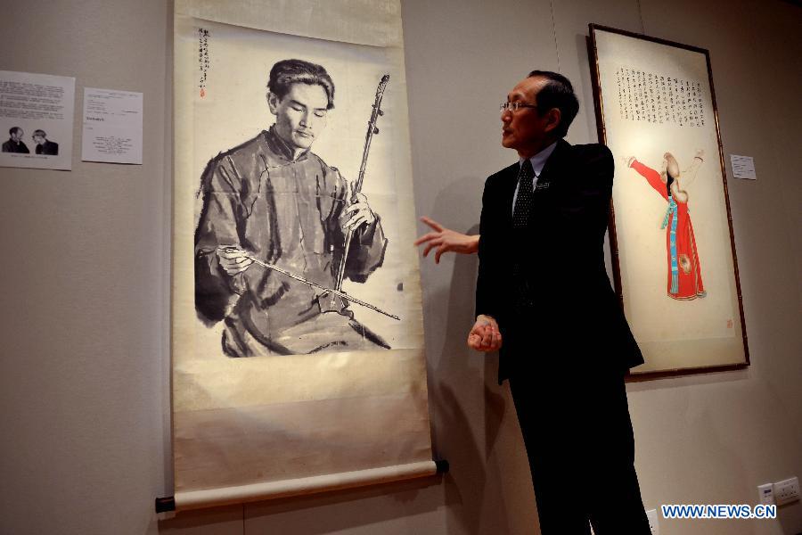A working staff from the Sotheby's presents an artwork by Jiang Zhaohe valued at 1.2 million to 1.8 million Hong Kong dollars (about 154,280 to 232,020 U.S. dollars) in Hong Kong, south China, March 13, 2013. Sotheby's 2013 spring sales of fine Chinese paintings will be held on April 5 in Hong Kong. Over 300 pieces of artworks with a total value of more than 130 million Hong Kong dollars (about 16.6 million U.S. dollars) will be on display. (Xinhua/Chen Xiaowei)