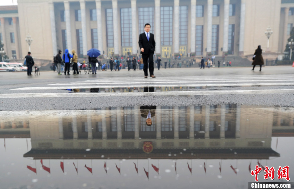 Photo shows the reflection of the Great Hall of the People in the rain puddle. The closing ceremony of the first session of the 12th National Committee of Chinese People’s Political Consultative Conference (CPPCC) was held at the Great Hall of the People in Beijing, capital of China, on March 12, 2013. (Chinanews.com/ Liu Zhongjun)