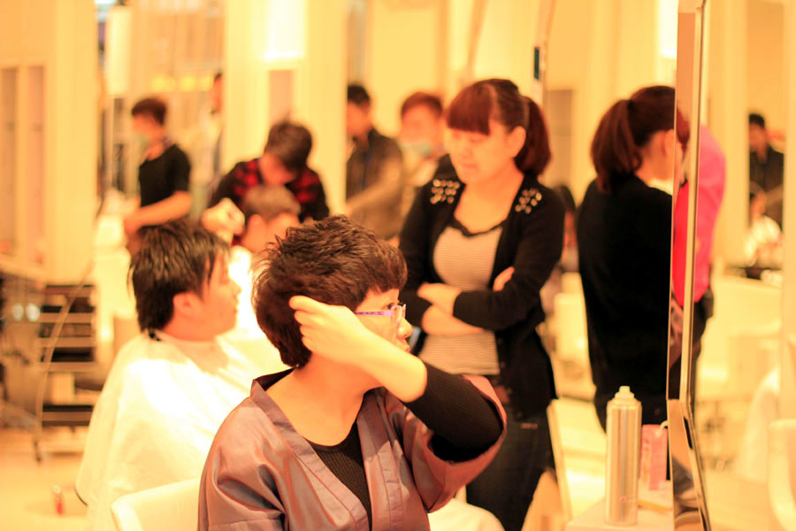 A customer fixes her hair in a barber shop at Wanda Plaza in Beijing on Wednesday, March 13, 2013. (CRIENGLISH.com/Liu Yuanhui)