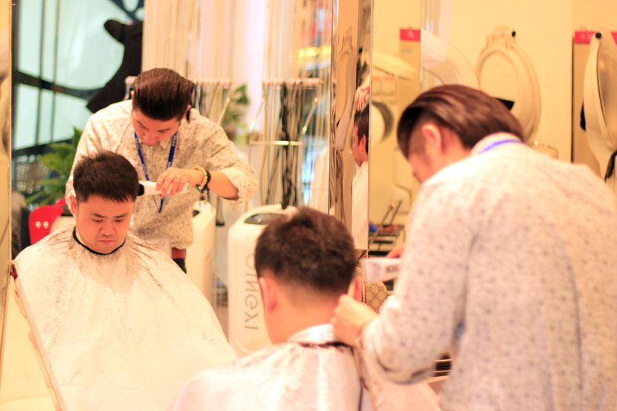A barber cuts a customer's hair in a barber shop at Wanda Plaza in Beijing on Wednesday, March 13, 2013. (CRIENGLISH.com/Liu Yuanhui)