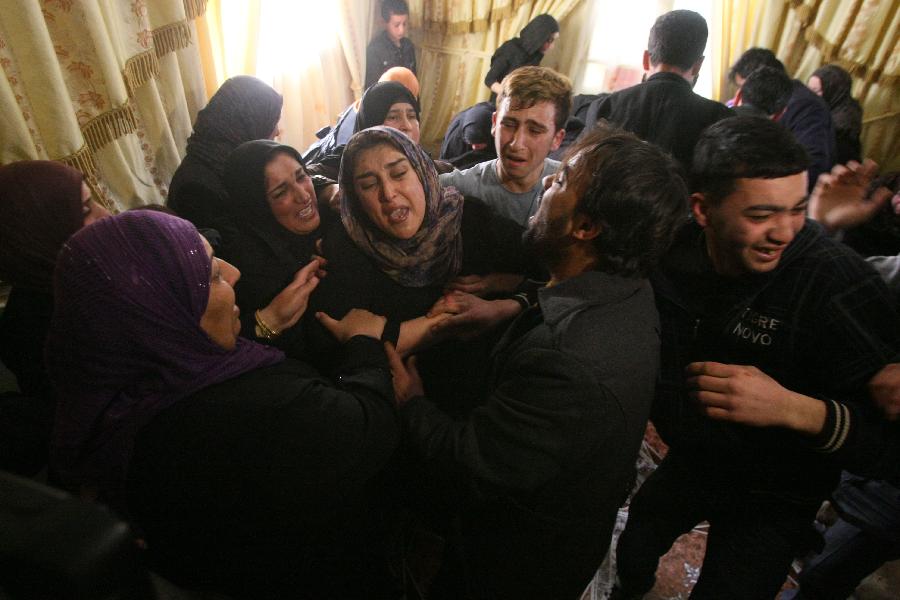 Relatives of Mahmoud Al-Titi mourns during his funeral in the West Bank city of Hebron, on March 13, 2013. Israeli forces shot dead a Palestinian and wounded two during clashes in the West Bank city of Hebron, medical sources and witnesses said Tuesday. (Xinhua/Mamoun Wazwaz)