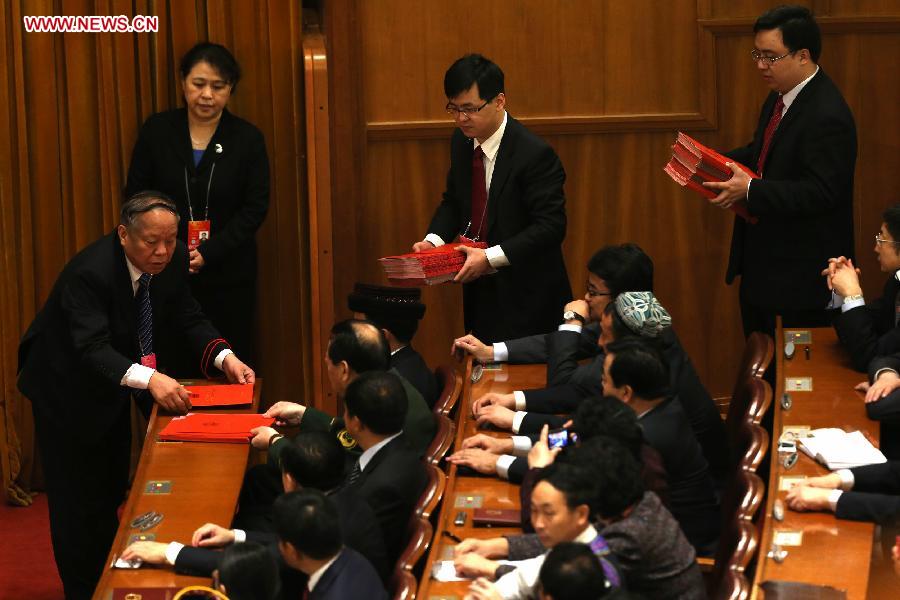 Staff members distribute ballots at the fourth plenary meeting of the first session of the 12th National People's Congress (NPC) at the Great Hall of the People in Beijing, capital of China, March 14, 2013. Chairman, vice-chairpersons, secretary-general and members of the 12th NPC Standing Committee, president and vice-president of the state, and chairman of the Central Military Commission of the People's Republic of China will be elected here on Thursday. (Xinhua/Jin Liwang) 