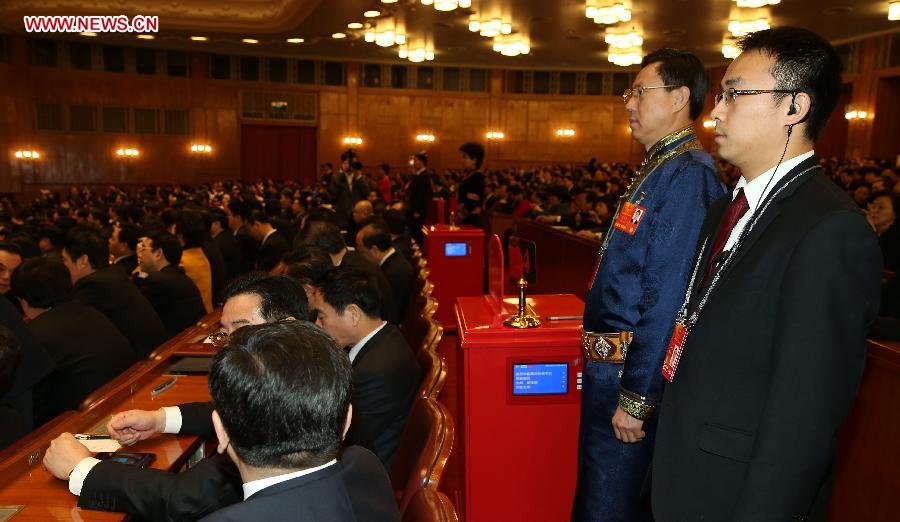 A staff member and a member of the intendancy stand beside a ballot box at the fourth plenary meeting of the first session of the 12th National People's Congress (NPC) at the Great Hall of the People in Beijing, capital of China, March 14, 2013. Chairman, vice-chairpersons, secretary-general and members of the 12th NPC Standing Committee, president and vice-president of the state, and chairman of the Central Military Commission of the People's Republic of China will be elected here on Thursday. (Xinhua/Chen Jianli)