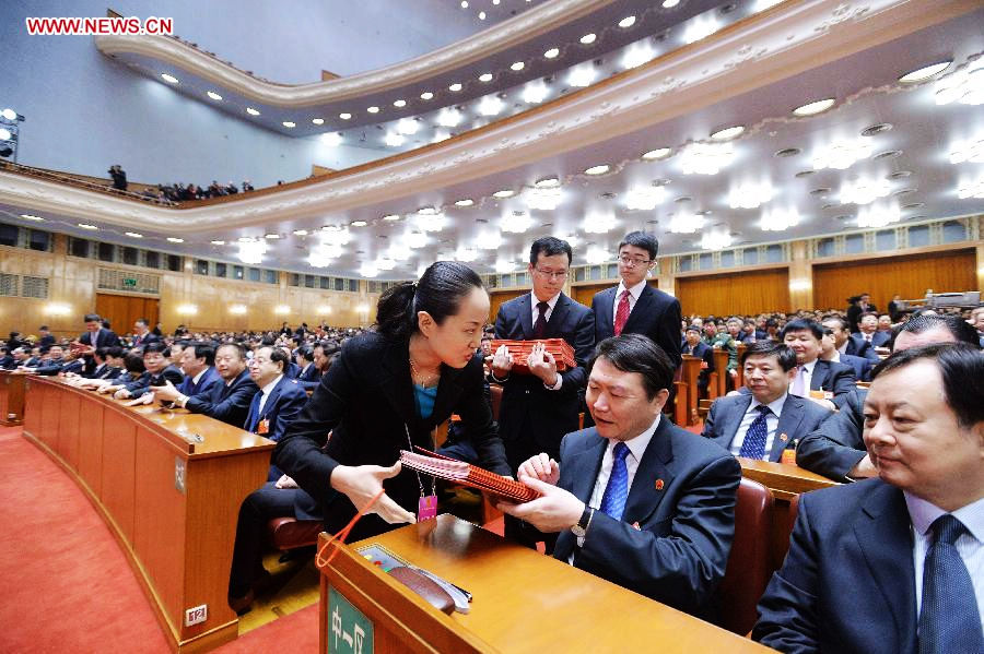 Staff members distribute ballots at the fourth plenary meeting of the first session of the 12th National People's Congress (NPC) at the Great Hall of the People in Beijing, capital of China, March 14, 2013. Chairman, vice-chairpersons, secretary-general and members of the 12th NPC Standing Committee, president and vice-president of the state, and chairman of the Central Military Commission of the People's Republic of China will be elected here on Thursday. (Xinhua/Li Tao)