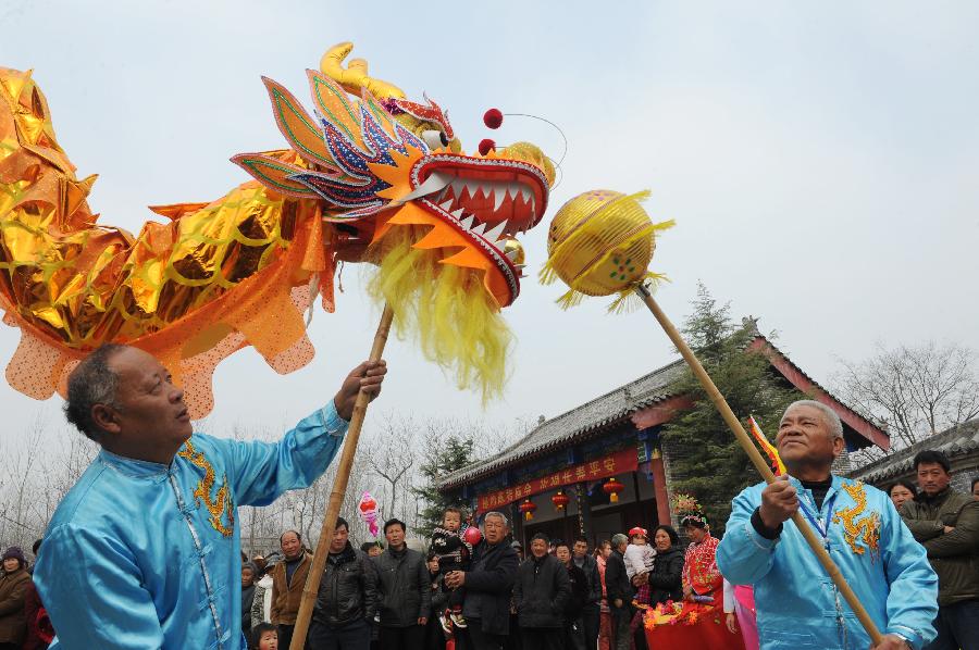 Folk artists play dragon dance during a temple fair in celebration of "Er Yue Er" in Bozhou City, east China's Anhui Province, March 13, 2013, on the occasion of the second day of the second lunar month, known in Chinese as Er Yue Er, "a time for the dragon to raise its head", as a Chinese saying goes. Various kinds of traditional activities were held all over the country to celebrate the festival to pray for a good harvest in the coming year. (Xinhua/Zhang Yanlin)