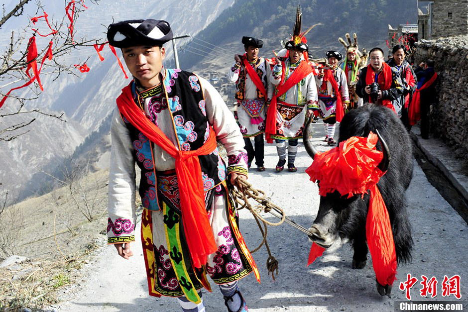 Men of Qiang nationality dressed in folk costumes carry sacrifice for the celebration for the Guai Ru Festival in Lixian county, southwest China's Sichuan province, March 13, 2013