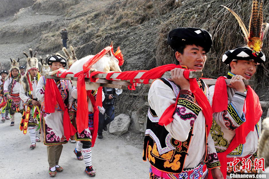 Men of Qiang nationality dressed in folk costumes carry sacrifice for the celebration for the Guai Ru Festival in Lixian county, southwest China's Sichuan province, March 13, 2013