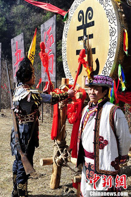 A man of Qiang nationality dressed in folk costumes gives taps on the drum during the a celebration for the Guai Ru Festival in Lixian county, southwest China's Sichuan province, March 13, 2013. (Chinanews/An Yuan)