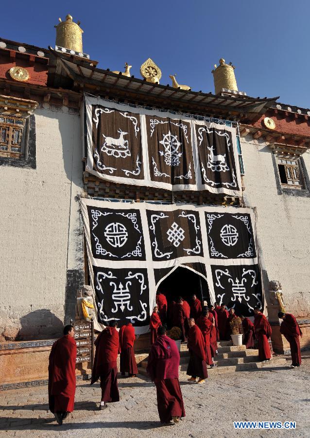 Buddhist monks prepare to go to the main hall to chant at the Ganden Stumtseling Monastery, the largest Tibetan Buddhism temple in Yunnan Province, in Shangri-la County, southwest China's Yunnan Province, March 14, 2013. (Xinhua/Lin Yiguang) 