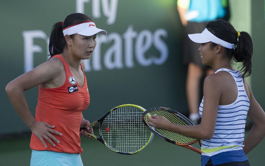 Peng Shuai (L) of China talks with Hsieh Su-Wei of Chinese Taipei during the women's doubles quarterfinal match against Daniela Hantuchova of Slovakia and Anabel Medina Garrigues of Spain at the BNP Paribas Open in Indian Wells, California, March 13, 2013. Peng Shuai and Hsieh Su-Wei won 2-1 to enter the semifinal. (Xinhua/Yang Lei)
