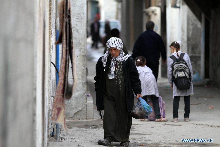 A Palestinian woman walks in the al-Shati refugee camp in Gaza City on March 13, 2013. About 700,000 Palestinians left their homes and settled in refugee camps in the Gaza Strip, the West Bank and neighboring Arab countries. (Xinhua/Yasser Qudih) 