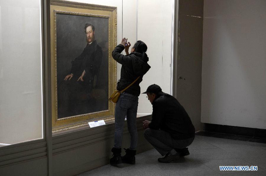 Visitors approach an art work at an exhibition showing British artworks in Nanchang, capital of east China's Jiangxi Province, March 14, 2013. An exhibition displaying 80 British art works kicked off here on Thursday. (Xinhua/Zhou Mi)